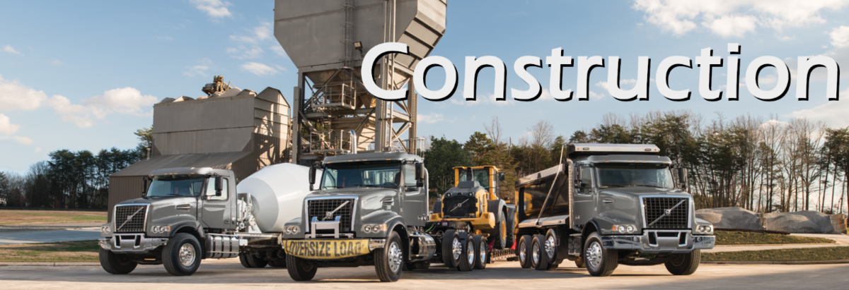 The word Construction, over top 3 large trucks